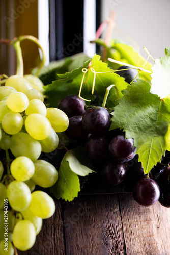 Mixes grape with bottle of wine on background
