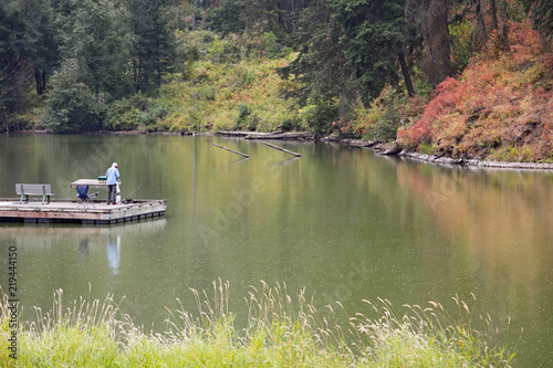 Photograph of a man fishing in a lake in autumn