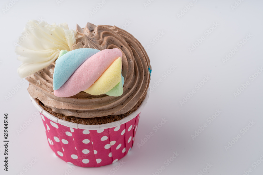 Tasty colorful cupcake isolated on white background, close up.