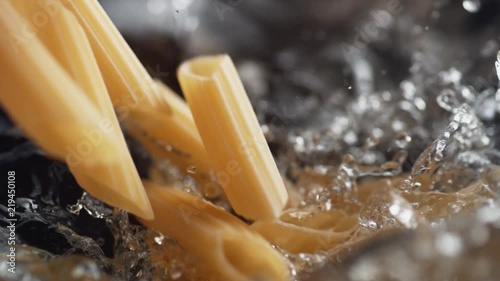 Throwing penne pasta into water. Shot with high speed camera, phantom flex 4K. Slow Motion.
