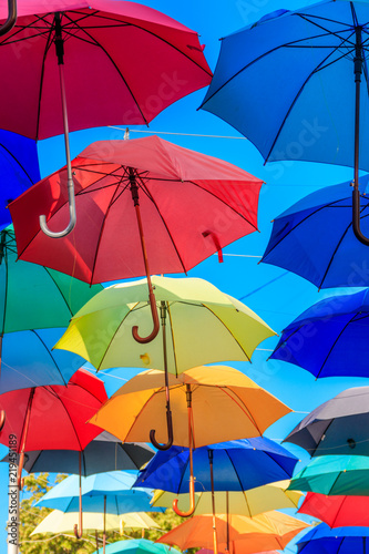 Multicolored umbrellas on the city street. The city street is decorated with many colorful open umbrellas © olyasolodenko