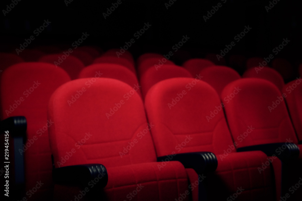 Obraz premium Many rows of red velvet seats in a cinema or theater stage, in semi-darkness. 