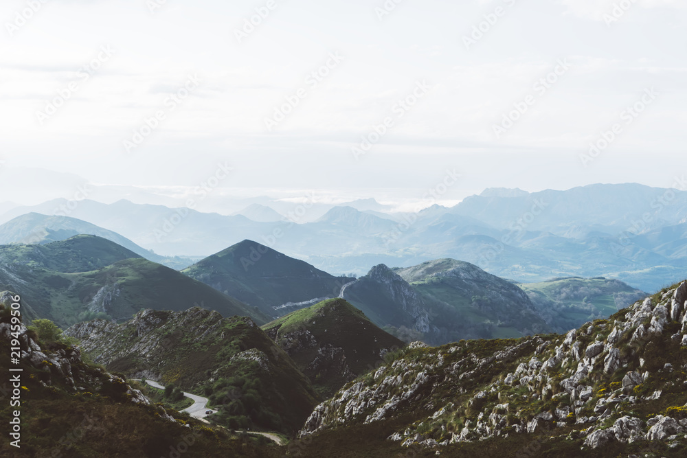 morning mist in the mountain peaks on natural landscape. Green valley on background foggy dramatic sky. Panorama horizon perspective view of scenery hills mountain tops. Travel mockup concept