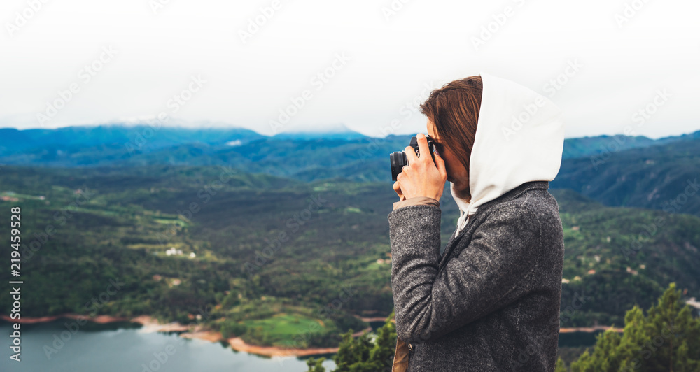 photographer tourist traveler standing on green top on mountain holding in hands digital photo camera, hiker taking click photography, nature panoramic landscape in trip, holiday hobby concept