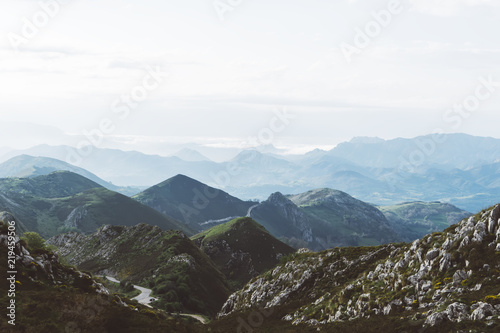 morning mist in the mountain peaks on natural landscape. Green valley on background foggy dramatic sky. Panorama horizon perspective view of scenery hills mountain tops. Travel mockup concept