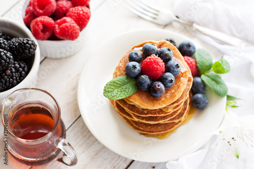 Paleo apple-cinnamon pancakes with berries, maple syrup photo