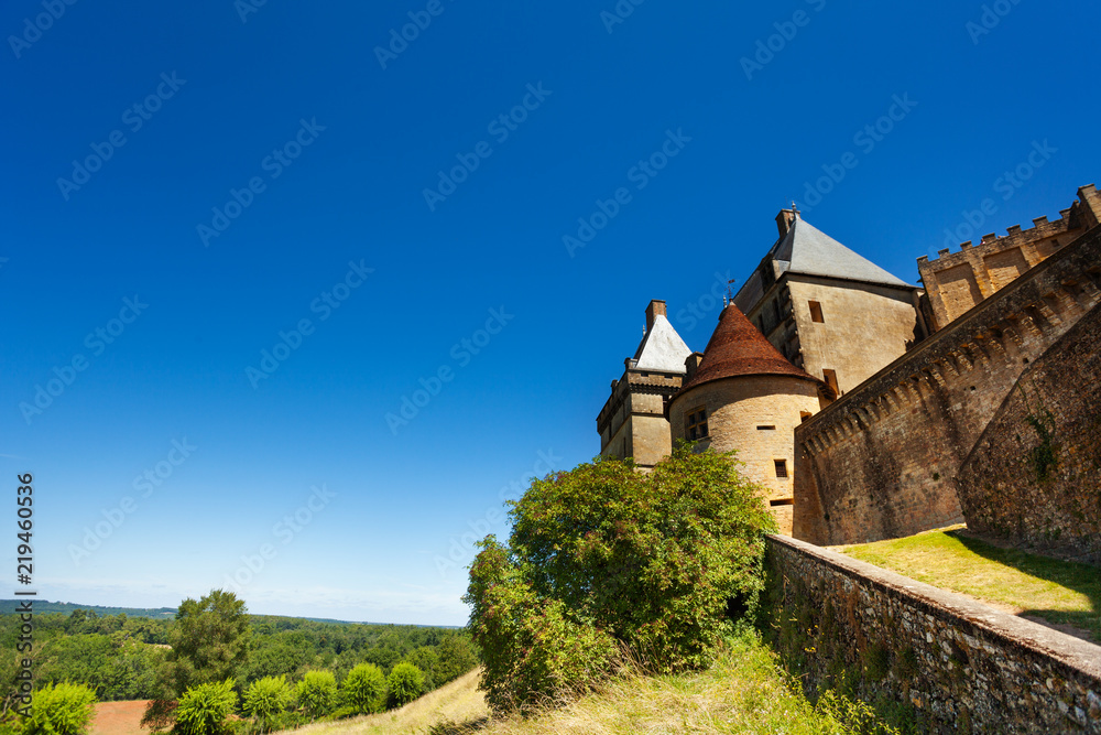 Medieval Biron castle against blue sky, France