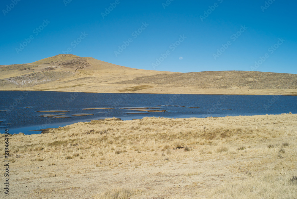 Serene Landscape with a Dark Blue Lake and Dried Golden Grass in Colca Valley, Peru