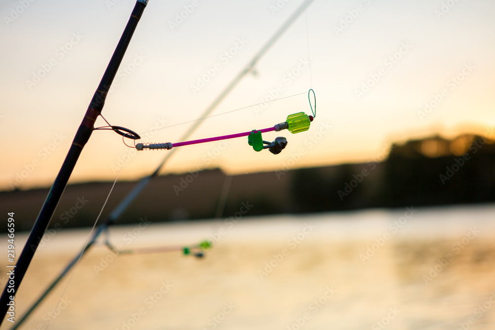 Bells for fish bites on fishing rod against background of lake. Bite alarm.  Feeder carp fishing. Stock Photo