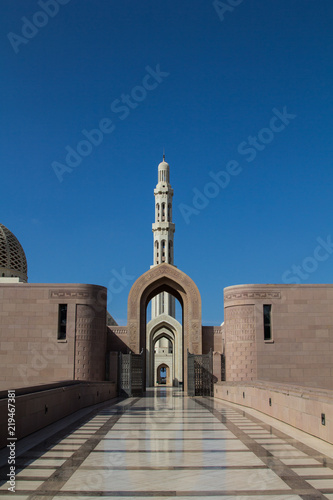 The marble floor leading to the entrance gate of the Sultan al Qaboos Grand mosque in Muscat, Sultanate of Oman, in the background, the minaret	 photo