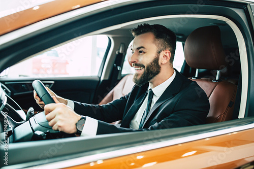 Portrait of happy businessman while driving his new car at first time © My Ocean studio