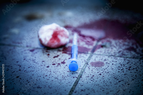 Used syringe and blood on dirty floor as symbol of narcotism and drug addiction. photo