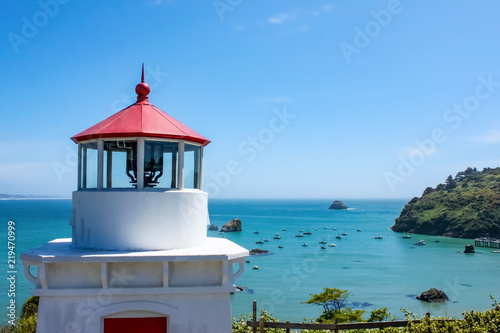 Closeup of Trinidad Head Lighthouse overlooking Trinidad bay California with boats anchored down below