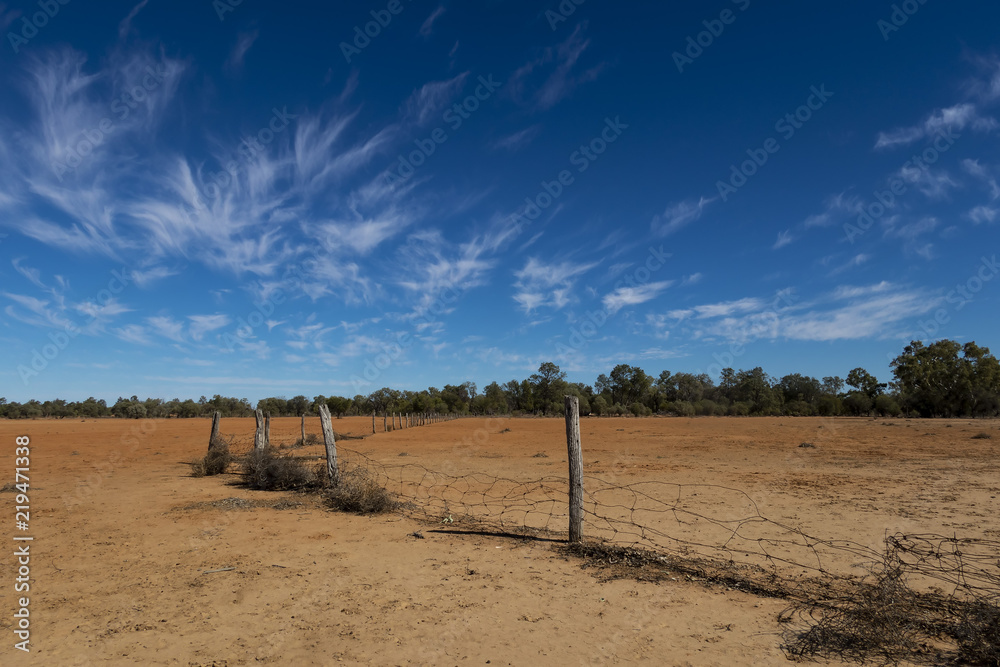 Old Wire Fence, blue sky and wispy clouds in the Australian outback