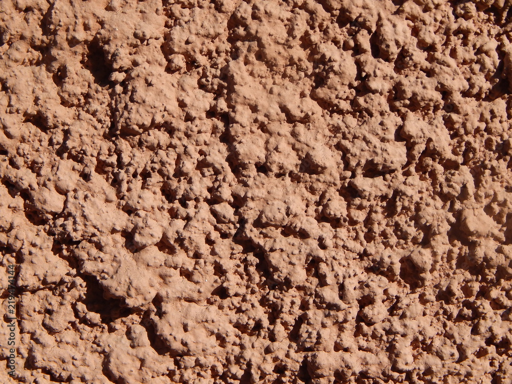 The wall, finished with brown plaster, the texture