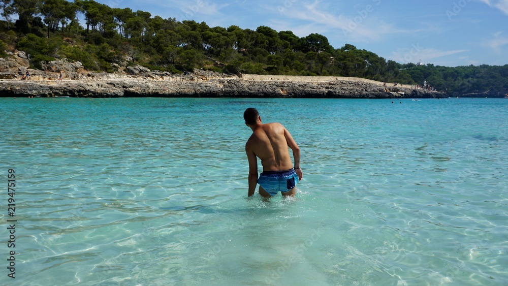 Chico en playa de agua turquesa. (S'Amarador, Mallorca)