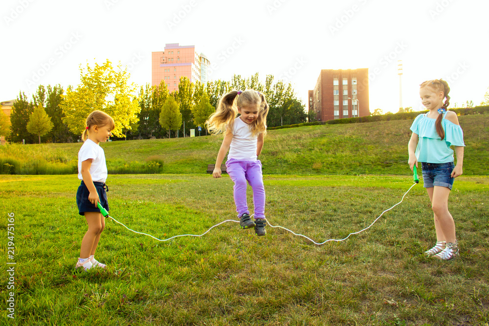 three cheerful girls are played with a rope