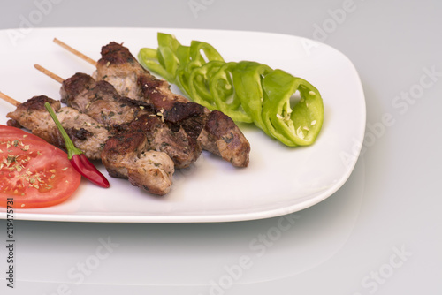 Pinchitos de cerdo con rodajas de tomates y pimientos photo