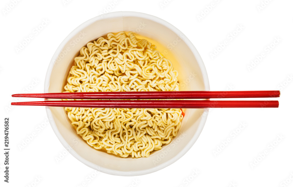 chopsticks over cup with dried instant noodles chopsticks over cup with dried instant noodles