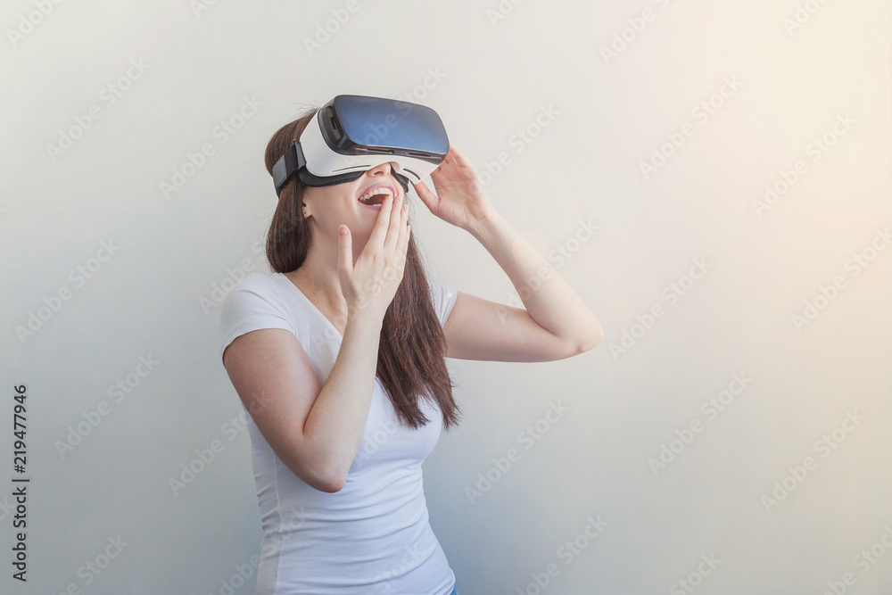 Smile young woman wearing using virtual reality VR glasses helmet headset on white background. Smartphone using with virtual reality goggles. Technology, simulation, hi-tech, videogame concept Smile young woman wearing using virtual reality VR glasses helmet headset on white background. Smartphone using with virtual reality goggles. Technology, simulation, hi-tech, videogame concept