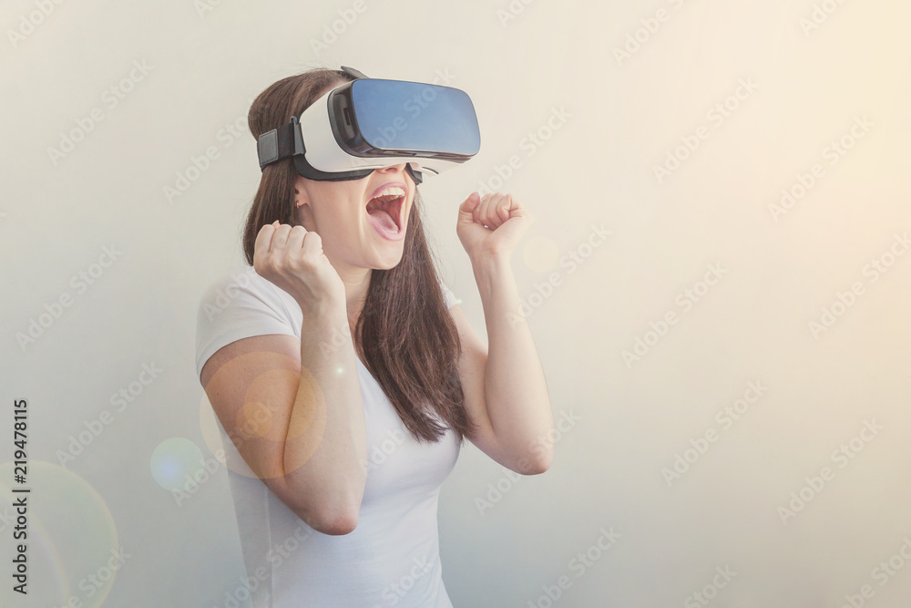 Smile young woman wearing using virtual reality VR glasses helmet headset on white background. Smartphone using with virtual reality goggles. Technology, simulation, hi-tech, videogame concept Smile young woman wearing using virtual reality VR glasses helmet headset on white background. Smartphone using with virtual reality goggles. Technology, simulation, hi-tech, videogame concept