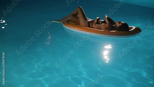 girl swimming on air mattress in pool