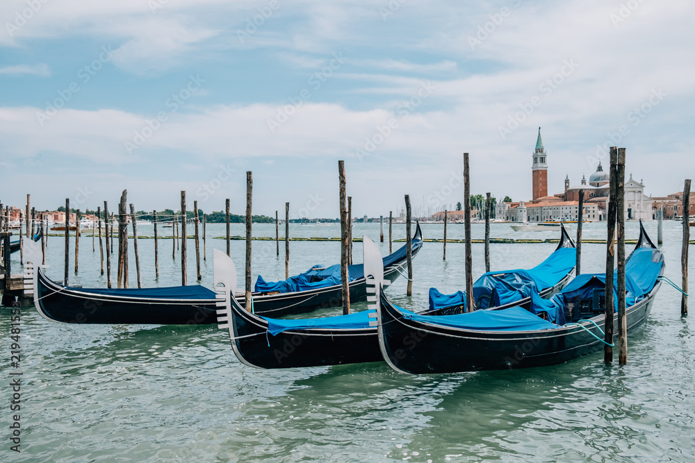 Parked gondolas on the water in the summer.
