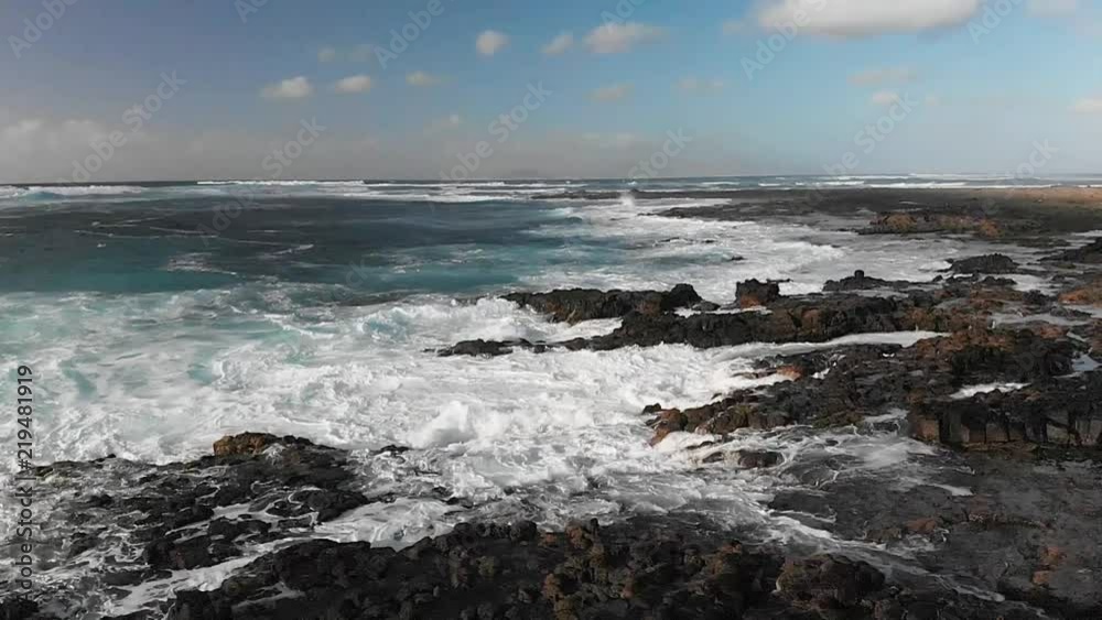Aerial, waves crash on rocky shore in slow motion Aerial, waves crash on rocky shore in slow motion