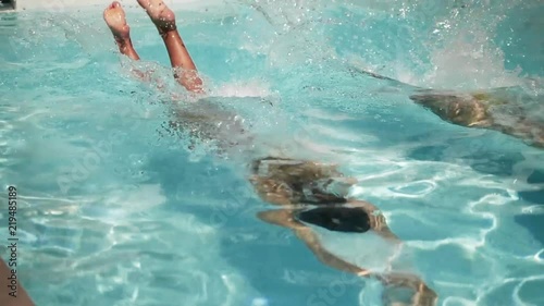 Women dive into pool, slow motion