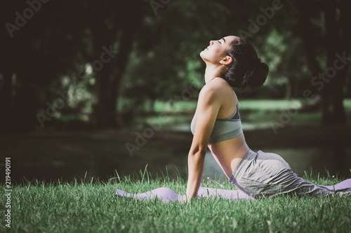 Fitness asian woman doing yoga in park photo