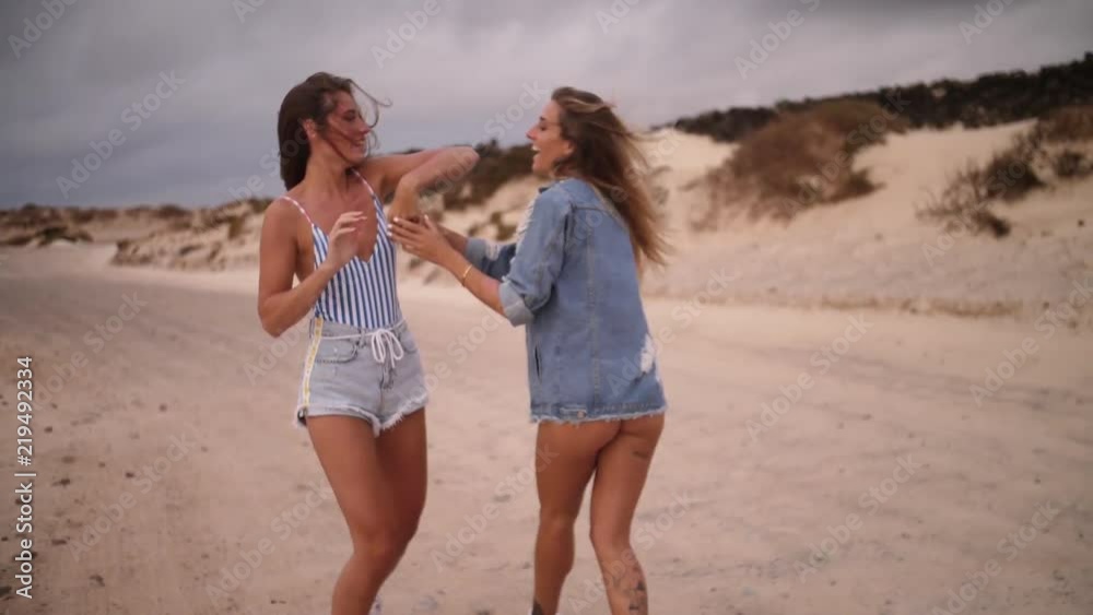 Slow motion, fashionable women walk on beach Slow motion, fashionable women walk on beach