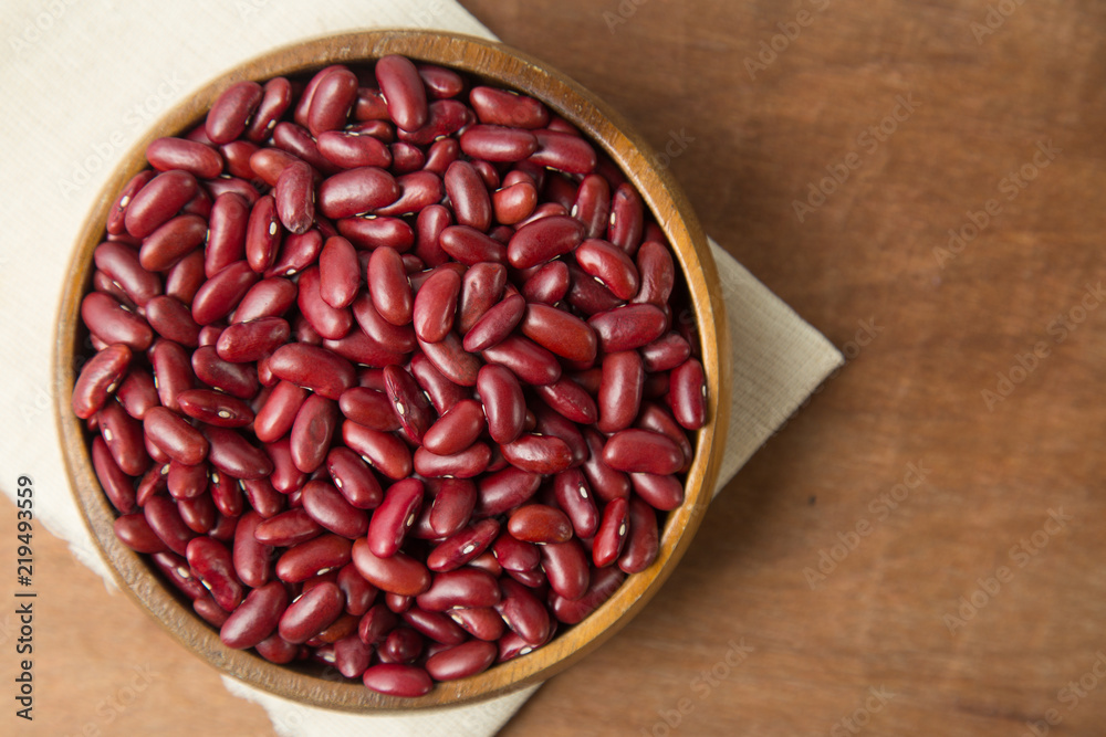 Red beans in wooden bowl putting on linen and wooden background. Red beans in wooden bowl putting on linen and wooden background.
