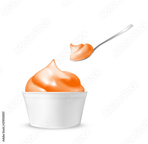 Orange ice cream in a cup with a spoon