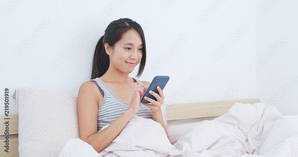 Woman use of mobile phone on bed Woman use of mobile phone on bed