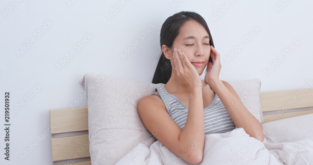 Woman do massaging on her face on bed Woman do massaging on her face on bed