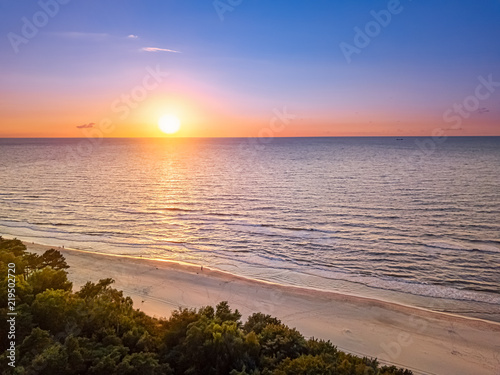 Herrlicher Sonnenuntergang über dem Meer, der Ostsee mit weißem Strand und leichten Wellen im heißen Sommer 2018 - die natur von ihrer schönsten Seite
