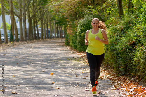Determined middle-aged woman jogging in the park