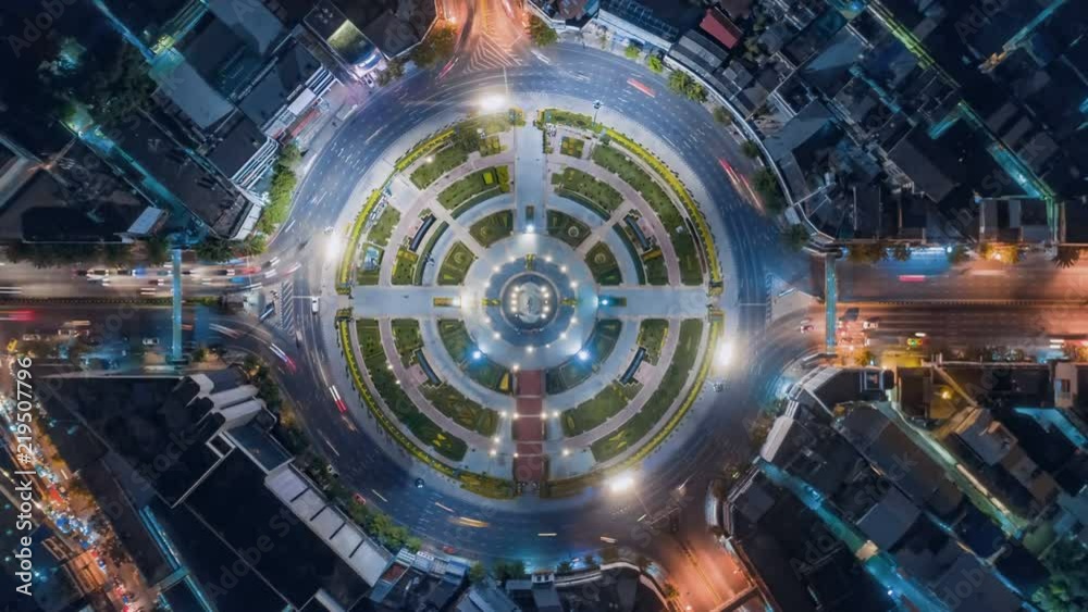 timelapse of night city traffic on 4-way stop street intersection circle roundabout in bangkok, thailand. 4K UHD horizontal aerial view.