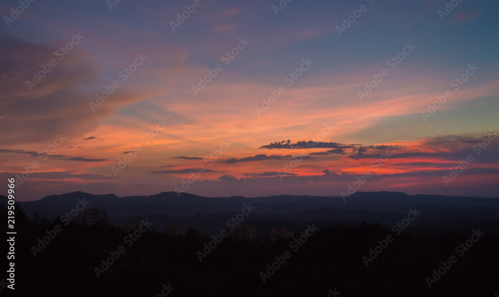 Obraz premium Sunset with silhouette of big mountain in summer