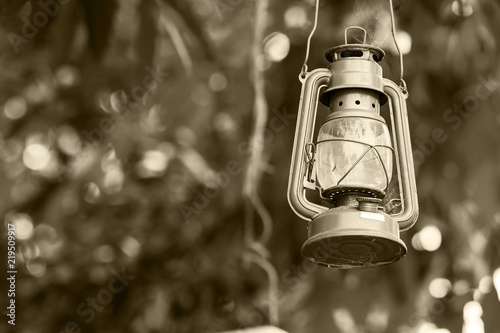 Antique oil lamp hanging on nature background in monochrome tone