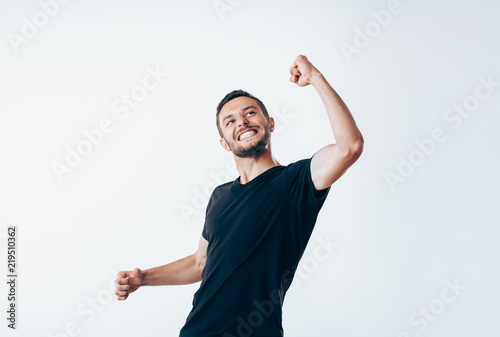 Handsome man with arms up celebrating success photo