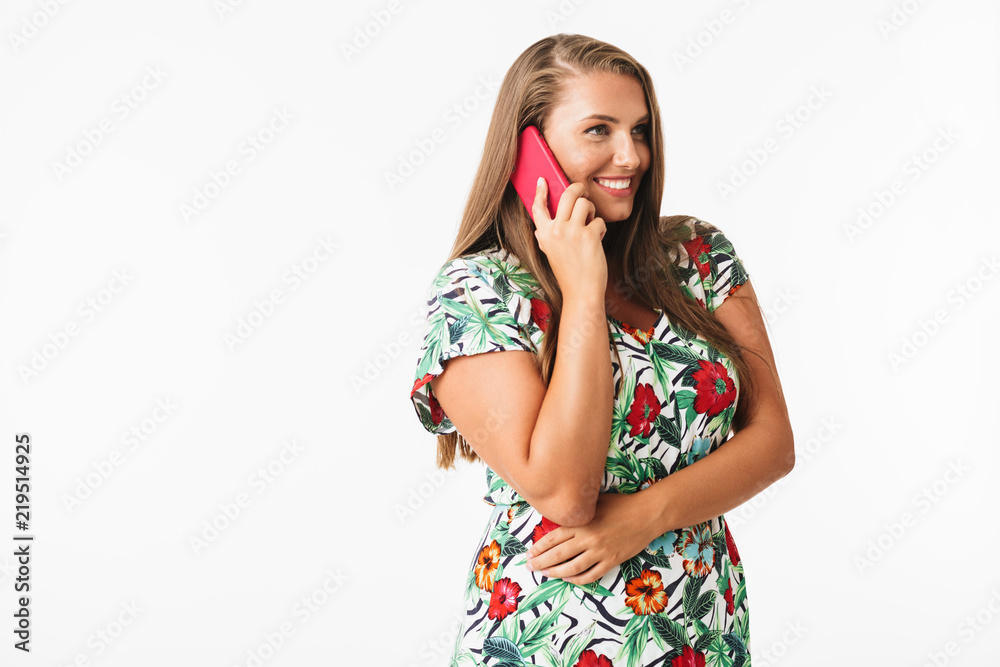 Smiling girl in colorful dress happily talking on cellphone looking aside over white background isolated. Plus size lady Smiling girl in colorful dress happily talking on cellphone looking aside over white background isolated. Plus size lady
