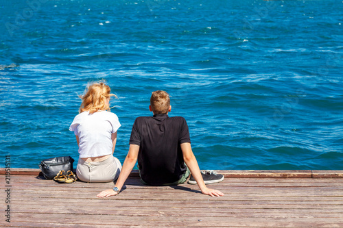 couple sitting on the pier on a Sunny day
