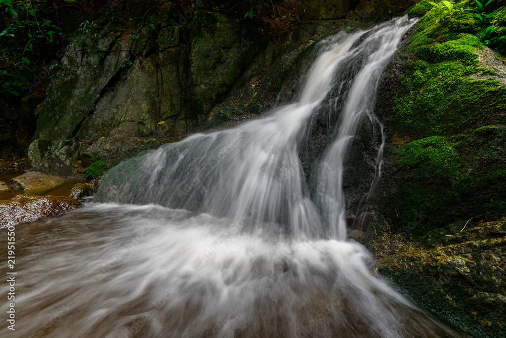 The water fall in the forest with sunlight