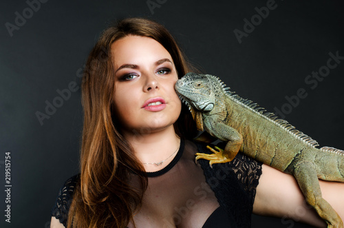 perfect sensual girl and big green iguana in the studio
