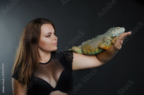 beautiful big tits girl and green iguana in the studio
