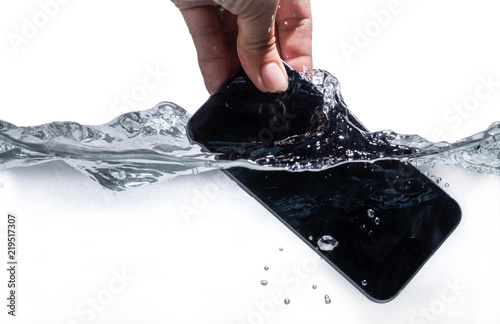 Hand keeping smartphone drop in water.