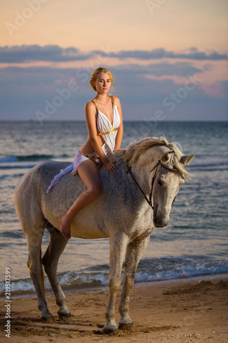 beautiful woman sitting on a horse on the beach