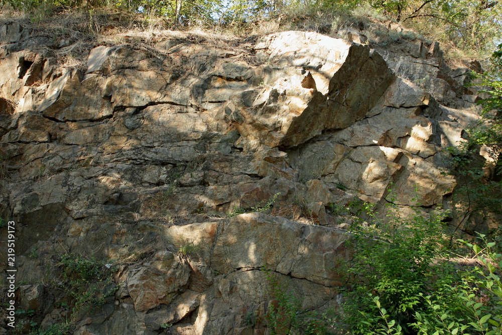 Granite rocks in the sun. Texture of granite stone. Background of natural material. Rocky rocks of ancient times. Minimalism Granite rocks in the sun. Texture of granite stone. Background of natural material. Rocky rocks of ancient times. Minimalism