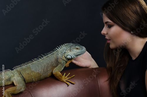 beautiful big tits girl and green iguana in the studio
